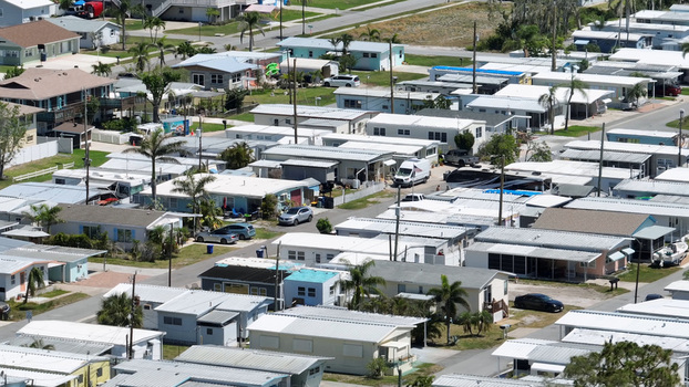 Aerial view of a residential mobile home park with rows of houses palm trees and parked cars in Cortez Florida United States.