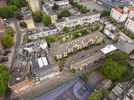 Aerial view of Shoreditch featuring residential apartment blocks a purple basketball court and surrounding urban streets in London England United Kingdom. Aerial view of Shoreditch featuring residential apartment blocks a purple basketball court and surrounding urban streets in London England United Kingdom.