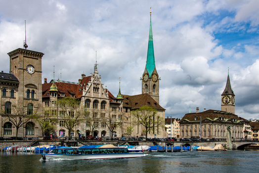 View of the historic Fraumunster church with its distinctive green spire and St. Peters Church along the Limmat River in Zurich Zurich Switzerland.
