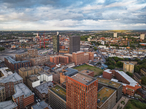 Aerial view of the Birmingham city skyline featuring modern brick apartment buildings high rise towers and dense urban development in Birmingham England United Kingdom.