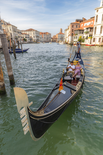 Venice Italy 21 September 2026 View of a gondolier rowing a couple in a traditional black gondola along a canal lined with historic buildings in Venice Italy. Venice Italy 21 September 2026 View of a gondolier rowing a couple in a traditional black gondola along a canal lined with historic buildings in Venice Italy.