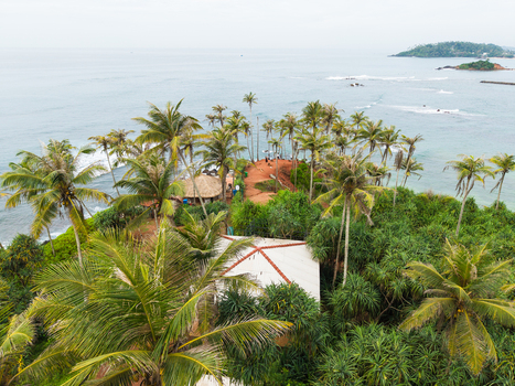Aerial view of Coconut Tree Hill with its iconic palm trees overlooking the Indian Ocean and distant islands Mirissa Southern Province Sri Lanka. Aerial view of Coconut Tree Hill with its iconic palm trees overlooking the Indian Ocean and distant islands Mirissa Southern Province Sri Lanka.