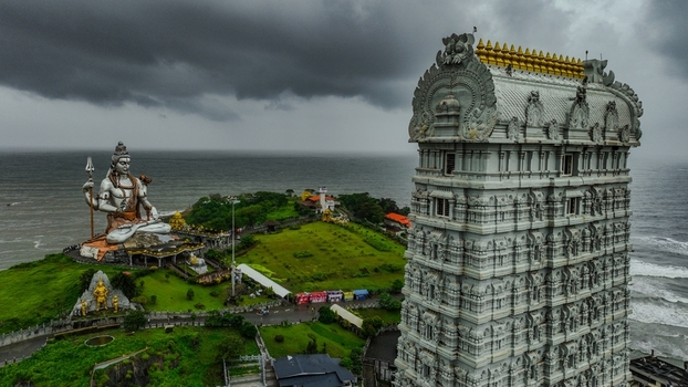 Aerial view of the Murudeshwar Temple and the giant Shiva statue overlooking the Arabian Sea under dramatic storm clouds in Murdeshwar Karnataka India.