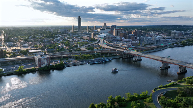 Aerial view of the Albany skyline Hudson River and highway interchange with a boat cruising on the water in Albany New York United States.