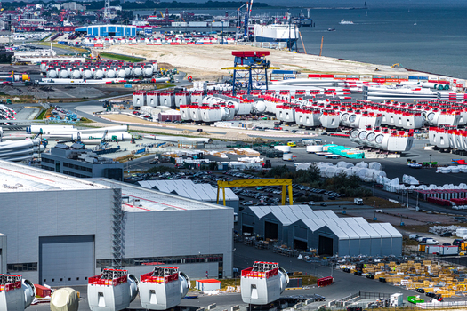 Aerial view of the Siemens Gamesa Renewable Energy facility with rows of wind turbine nacelles and blades stored on industrial grounds near the harbor in Cuxhaven Niedersachsen Germany.