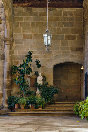 Plasencia Spain 03 December 2025 View of the interior courtyard of the Catedral Nueva de Plasencia featuring a hanging lantern stone walls and a religious statue. Plasencia Spain 03 December 2025 View of the interior courtyard of the Catedral Nueva de Plasencia featuring a hanging lantern stone walls and a religious statue.