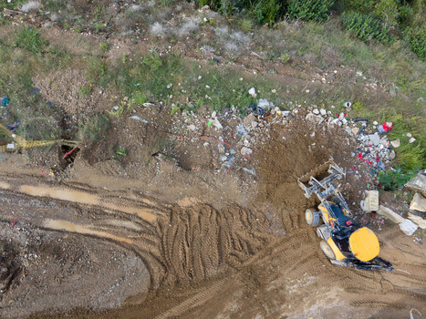 Aerial view of a yellow backhoe loader working on a muddy construction site with visible tire tracks and scattered debris in Istanbul Istanbul Turkiye. Aerial view of a yellow backhoe loader working on a muddy construction site with visible tire tracks and scattered debris in Istanbul Istanbul Turkiye.
