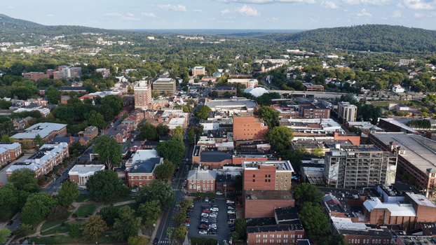 Aerial view of the historic downtown area with dense tree canopy and urban architecture in Charlottesville Virginia United States. Aerial view of the historic downtown area with dense tree canopy and urban architecture in Charlottesville Virginia United States.