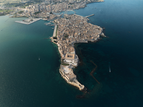 Aerial view of the Island of Ortigia featuring Maniace Castle and historic architecture surrounded by the Mediterranean Sea in Syracuse Sicily Italy. Aerial view of the Island of Ortigia featuring Maniace Castle and historic architecture surrounded by the Mediterranean Sea in Syracuse Sicily Italy.