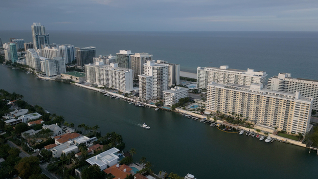 Aerial view of the Miami Beach skyline along the waterway with modern high rise residential buildings and boats docked along the shore in Miami Beach Florida United States. Aerial view of the Miami Beach skyline along the waterway with modern high rise residential buildings and boats docked along the shore in Miami Beach Florida United States.