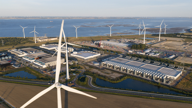 Aerial view of wind turbines and a large industrial data center facility located near the coast in Eemshaven Groningen Netherlands.