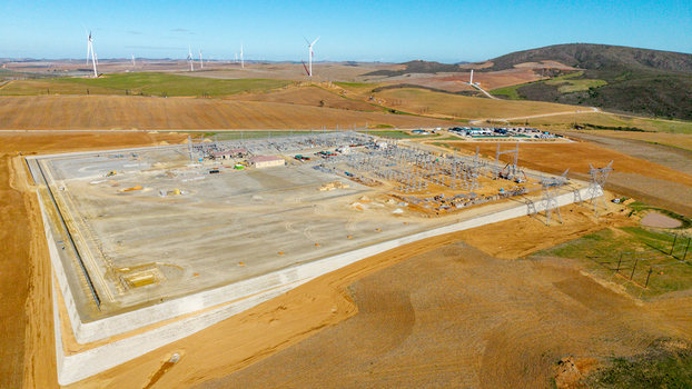 Aerial view of an electrical substation and wind farm with turbines on rolling hills under a clear blue sky Swellendam Western Cape South Africa. Aerial view of an electrical substation and wind farm with turbines on rolling hills under a clear blue sky Swellendam Western Cape South Africa.