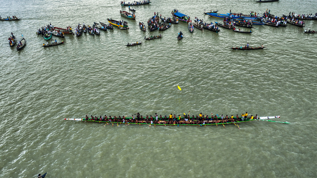 Baghabari Bangladesh 20 August 2022 Aerial view of a traditional long boat race on the river with many spectators in small boats watching the competition.