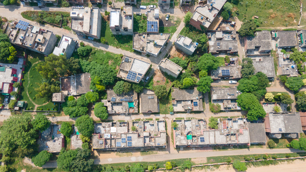 Lahore Punjab Pakistan 08 September 2026 Aerial view of Government Officers Colony featuring residential houses with flat roofs solar panels and surrounding greenery.