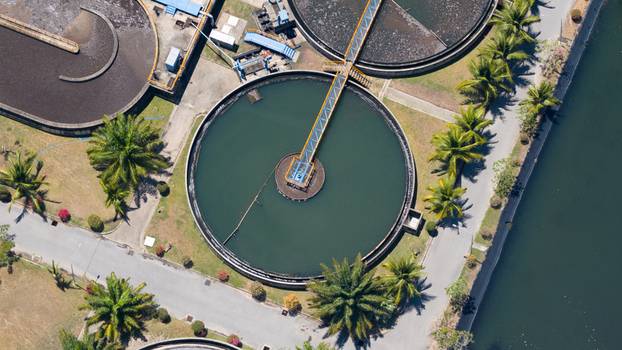 Aerial view of circular sedimentation tanks at a wastewater treatment plant surrounded by palm trees and paved paths in Phuket Phuket Thailand. Aerial view of circular sedimentation tanks at a wastewater treatment plant surrounded by palm trees and paved paths in Phuket Phuket Thailand.