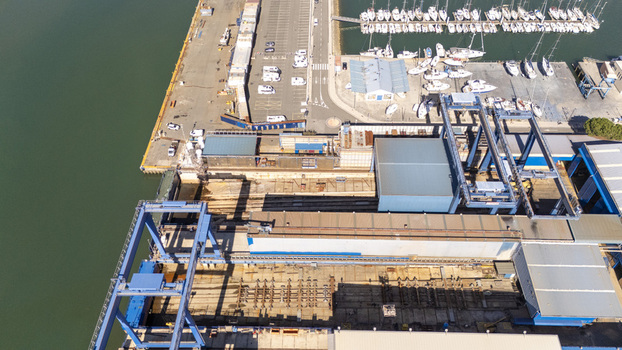 Aerial view of the shipyard and marina in Zumaia featuring industrial cranes dry dock facilities and numerous sailboats moored in the harbor in Zumaia Basque Country Spain.