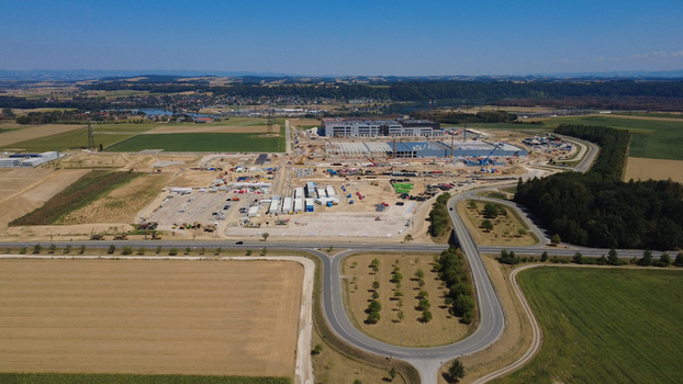Aerial view of a large data center construction site with industrial buildings cranes and heavy machinery surrounded by agricultural fields and roads in Kronstorf Upper Austria Austria. Aerial view of a large data center construction site with industrial buildings cranes and heavy machinery surrounded by agricultural fields and roads in Kronstorf Upper Austria Austria.