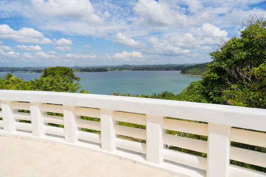 View of the turquoise waters of Unawatuna Bay from the Japanese Peace Pagoda terrace surrounded by lush tropical greenery Unawatuna Southern Province Sri Lanka. View of the turquoise waters of Unawatuna Bay from the Japanese Peace Pagoda terrace surrounded by lush tropical greenery Unawatuna Southern Province Sri Lanka.