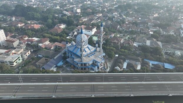 Aerial view of the Al Azhar Mosque with its distinctive blue dome and minarets situated near a highway in a residential area of Bekasi Barat West Java Indonesia. Aerial view of the Al Azhar Mosque with its distinctive blue dome and minarets situated near a highway in a residential area of Bekasi Barat West Java Indonesia.