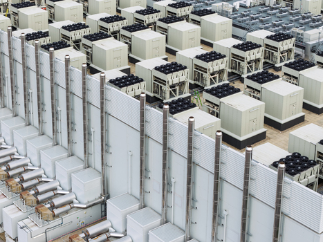 Aerial view of a data center featuring rows of industrial cooling units HVAC systems and ventilation pipes United Kingdom.
