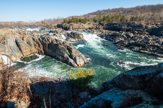 View of the powerful rushing water carving its way through the rugged rocks a natural spectacle of raw beauty and untamed wilderness Great Falls Virginia United States. View of the powerful rushing water carving its way through the rugged rocks a natural spectacle of raw beauty and untamed wilderness Great Falls Virginia United States.