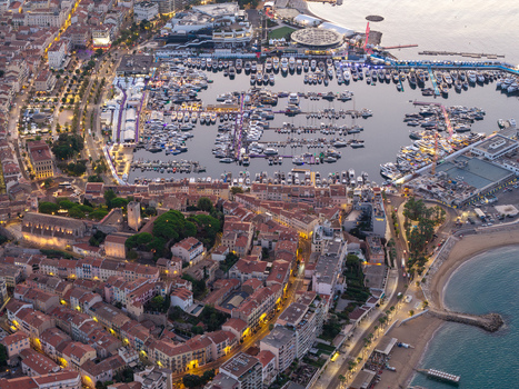 Aerial view of the Vieux Port in Cannes with yachts and boats surrounded by historic buildings urban rooftops and Mediterranean coastline in Cannes Provence Alpes Cote d Azur France. Aerial view of the Vieux Port in Cannes with yachts and boats surrounded by historic buildings urban rooftops and Mediterranean coastline in Cannes Provence Alpes Cote d Azur France.