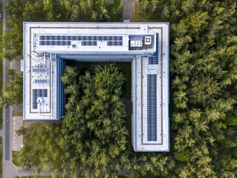 Aerial view of ASML Building 26 at High Tech Campus featuring rooftop solar panels surrounded by dense forest in Eindhoven Noord Brabant Netherlands. Aerial view of ASML Building 26 at High Tech Campus featuring rooftop solar panels surrounded by dense forest in Eindhoven Noord Brabant Netherlands.