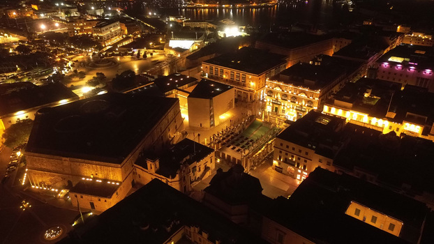 Aerial view of the illuminated historic city center of Valletta at night featuring the Parliament Building and City Gate area with glowing streetlights in Valletta Port Region Malta. Aerial view of the illuminated historic city center of Valletta at night featuring the Parliament Building and City Gate area with glowing streetlights in Valletta Port Region Malta.