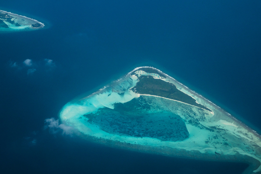 Aerial view of turquoise waters embracing the pristine white sands of the atoll a jewel in the vast ocean Flight from Male to Hanimaadhoo island Maldives.