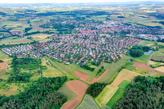 Aerial view of the town of Neunkirchen am Brand with its red roofed houses surrounded by lush green fields and forests in Neunkirchen am Brand Bavaria Germany. Aerial view of the town of Neunkirchen am Brand with its red roofed houses surrounded by lush green fields and forests in Neunkirchen am Brand Bavaria Germany.