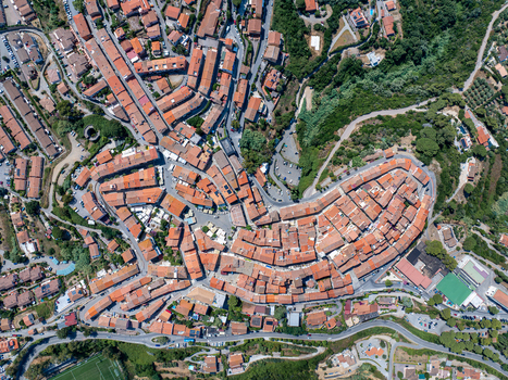 Aerial view of the historic town of Capoliveri with its dense terracotta rooftops narrow winding streets and surrounding lush Mediterranean landscape in Capoliveri Tuscany Italy.