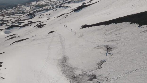 Aerial view of people hiking on the snowy slopes of Mount Etna Italy. Aerial view of people hiking on the snowy slopes of Mount Etna Italy.