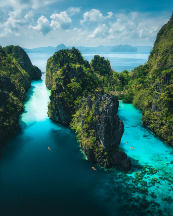 Aerial view of Big Lagoon with turquoise waters towering limestone cliffs and kayaks in El Nido Bay Philippines. Aerial view of Big Lagoon with turquoise waters towering limestone cliffs and kayaks in El Nido Bay Philippines.