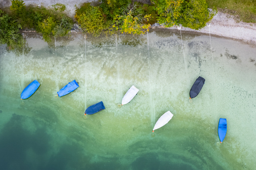 Aerial view of boats resting on the tranquil shores of Plansee where the turquoise waters meet the soft sandy beach Plansee Tyrol Austria. Aerial view of boats resting on the tranquil shores of Plansee where the turquoise waters meet the soft sandy beach Plansee Tyrol Austria.