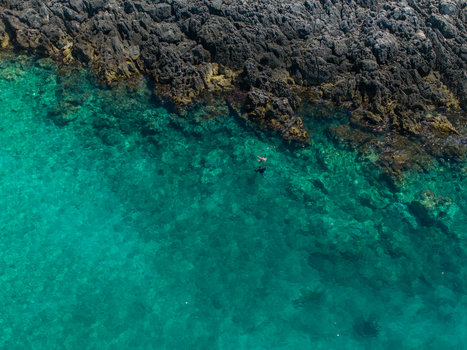 Aerial view of people swimming in the turquoise water of Aquarium Beach along the rocky coastline in Jala Vlore County Albania. Aerial view of people swimming in the turquoise water of Aquarium Beach along the rocky coastline in Jala Vlore County Albania.