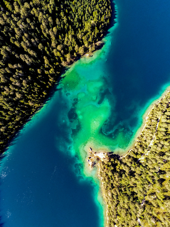 Aerial view of Blindsee with its vibrant turquoise and deep blue waters surrounded by dense evergreen forests in Biberwier Tyrol Austria. Aerial view of Blindsee with its vibrant turquoise and deep blue waters surrounded by dense evergreen forests in Biberwier Tyrol Austria.