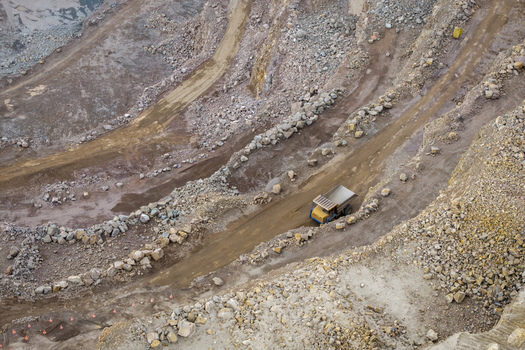 Aerial view of the Porphyry and Diabase Mine featuring a large haul truck driving along a dirt road within the rocky quarry landscape of Krakow Lesser Poland Voivode Poland. Aerial view of the Porphyry and Diabase Mine featuring a large haul truck driving along a dirt road within the rocky quarry landscape of Krakow Lesser Poland Voivode Poland.