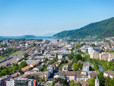 Aerial view of the Biel Bienne Bozingenfeld Champ industrial area with the railway yard and Lake Biel under a clear blue sky in Biel Bienne Canton of Bern Switzerland.