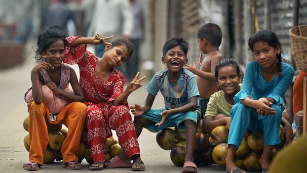 View of children smiling and sitting on coconuts in Bogura Bangladesh. View of children smiling and sitting on coconuts in Bogura Bangladesh.