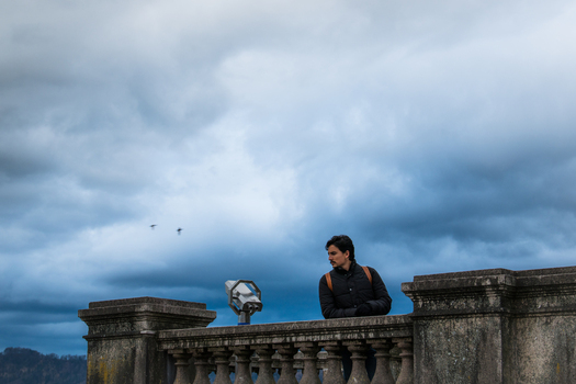 Zurich Switzerland 02 April 2023 View of a lone figure stands pensively by the weathered stone balustrade of the National Museum gazing out at the expansive sky. Zurich Switzerland 02 April 2023 View of a lone figure stands pensively by the weathered stone balustrade of the National Museum gazing out at the expansive sky.