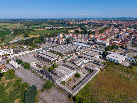 Aerial view of the industrial complex with warehouses and factory buildings on the outskirts of the town surrounded by residential areas and fields in Casale Monferrato Piedmont Italy. Aerial view of the industrial complex with warehouses and factory buildings on the outskirts of the town surrounded by residential areas and fields in Casale Monferrato Piedmont Italy.
