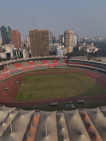 Aerial view of Bangabandhu National Stadium with its red and white seating and green pitch set against the dense urban skyline of Dhaka Dhaka Division Bangladesh. Aerial view of Bangabandhu National Stadium with its red and white seating and green pitch set against the dense urban skyline of Dhaka Dhaka Division Bangladesh.