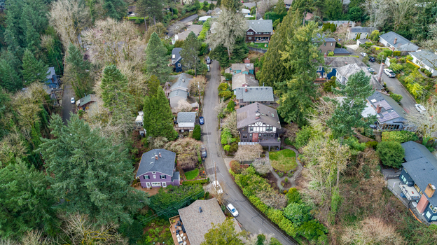 Aerial view of Northwest Imperial Terrace residential street with houses nestled among lush evergreen trees and early spring foliage in Portland Oregon United States. Aerial view of Northwest Imperial Terrace residential street with houses nestled among lush evergreen trees and early spring foliage in Portland Oregon United States.