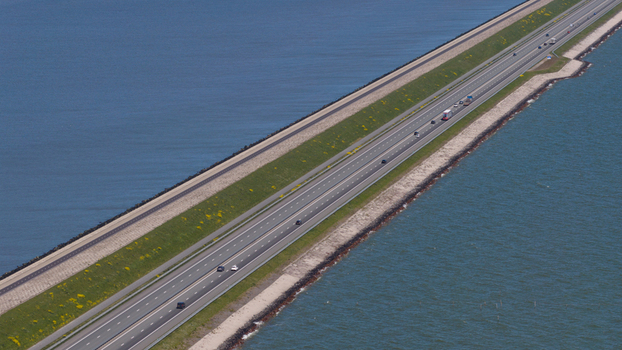 Aerial view of the Afsluitdijk causeway with traffic on the highway and water on both sides in Breezanddijk Friesland Netherlands.