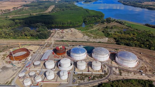 Aerial view of industrial fuel storage tanks with white spherical and cylindrical containers a construction site with an empty tank shell and greenery in Kovin Vojvodina Serbia. Aerial view of industrial fuel storage tanks with white spherical and cylindrical containers a construction site with an empty tank shell and greenery in Kovin Vojvodina Serbia.