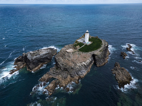 Aerial view of Godrevy Lighthouse on a rocky island surrounded by the blue waters of the Atlantic Ocean Gwithian England United Kingdom. Aerial view of Godrevy Lighthouse on a rocky island surrounded by the blue waters of the Atlantic Ocean Gwithian England United Kingdom.