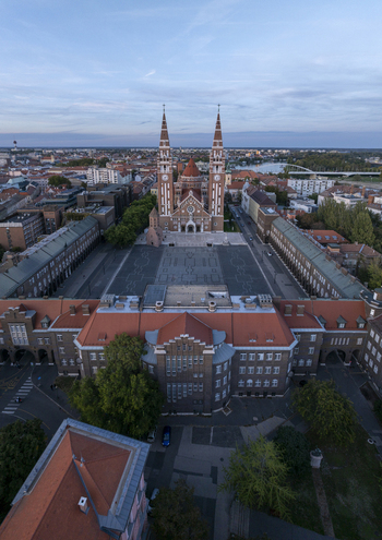 Aerial view of Szeged Cathedral a prominent brick church with twin spires overlooking the expansive Dom ter square surrounded by historic buildings in Szeged Hungary. Aerial view of Szeged Cathedral a prominent brick church with twin spires overlooking the expansive Dom ter square surrounded by historic buildings in Szeged Hungary.