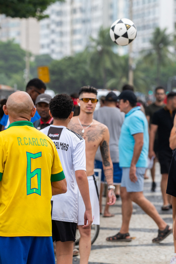 Rio de Janeiro Brazil 13 June 2026 View of people gathered on the Copacabana sidewalk during the World Cup 2026 with a football in the air and fans wearing Brazil jerseys.