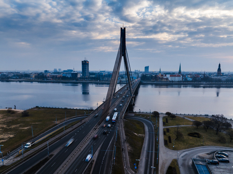 Aerial view of Vansu Bridge spanning the Daugava River with traffic flowing across the cable stayed structure and the city skyline in the background in Riga Latvia. Aerial view of Vansu Bridge spanning the Daugava River with traffic flowing across the cable stayed structure and the city skyline in the background in Riga Latvia.
