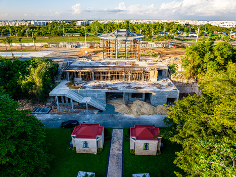 Aerial view of the Casa Arquidiocesana Maria de La Altagracia construction site featuring concrete framing and lush green trees in Santo Domingo Este Santo Domingo Provinc Dominican Republic. Aerial view of the Casa Arquidiocesana Maria de La Altagracia construction site featuring concrete framing and lush green trees in Santo Domingo Este Santo Domingo Provinc Dominican Republic.